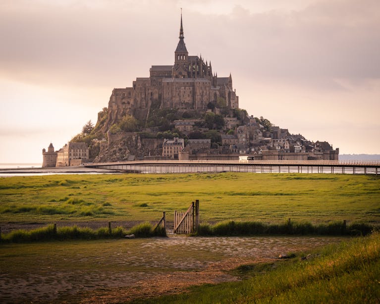 experience the enchanting view of mont saint michel a landmark in france surrounded by tidal waters at sunset. 24801679 scaled