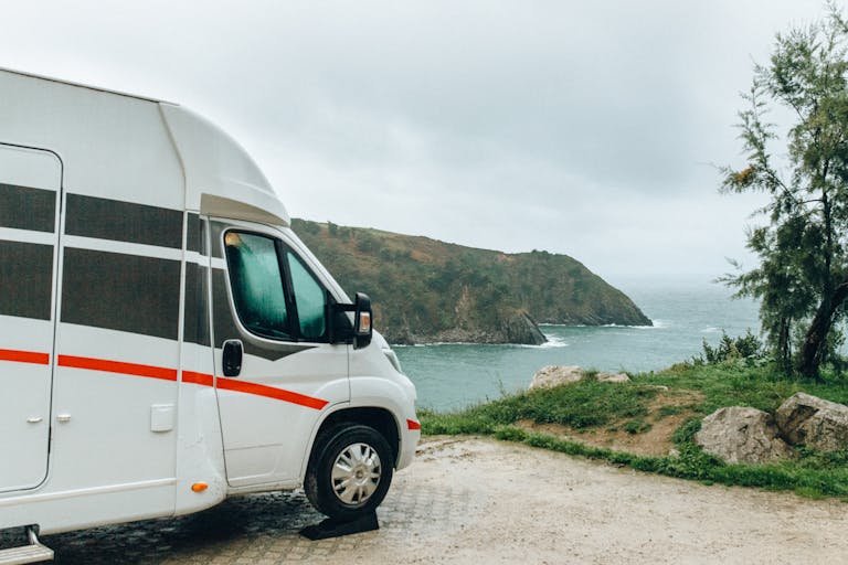 scenic view of a camper van parked by the ocean cliffs on a cloudy day. 5712703 scaled